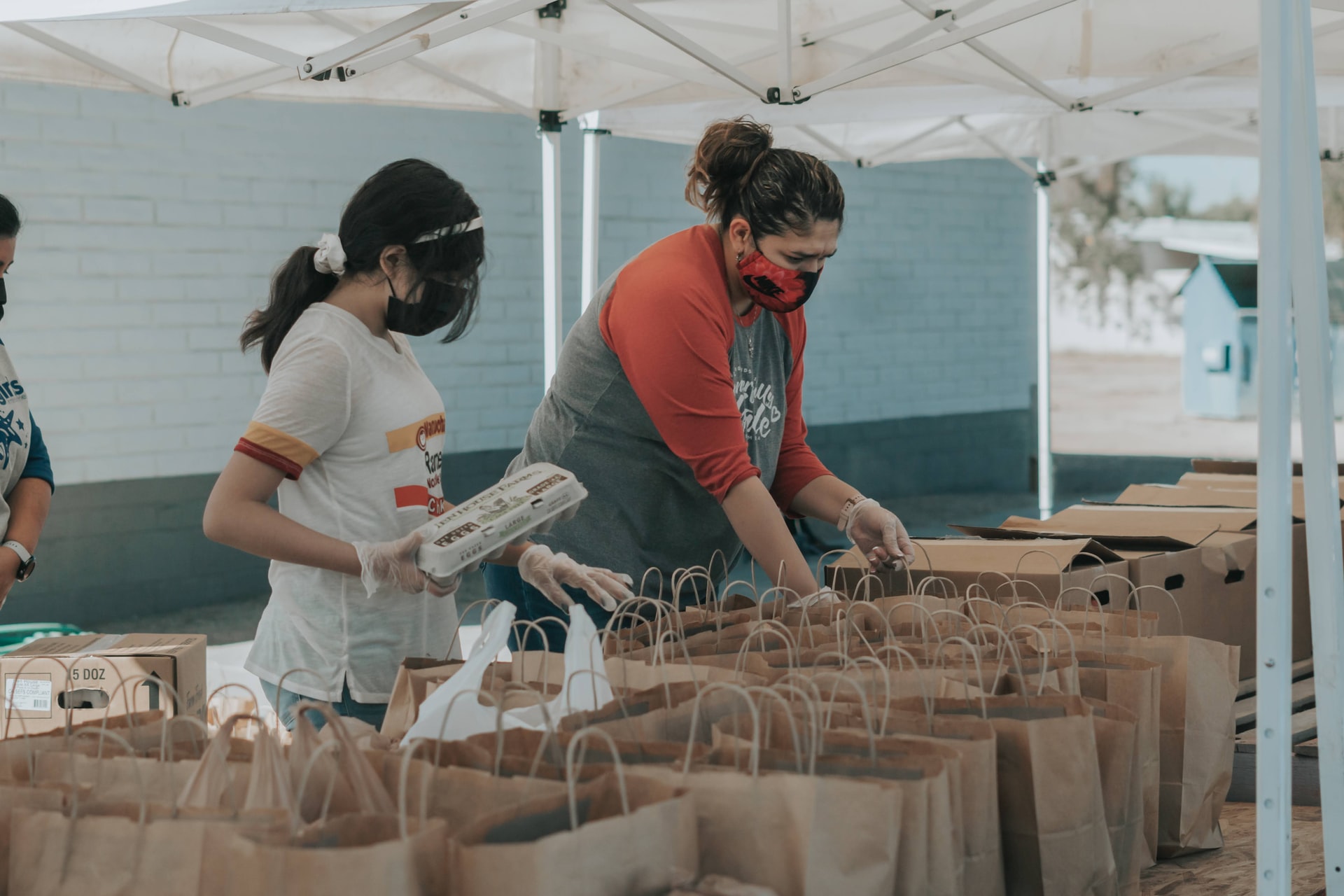 a group of colleagues volunteering and filling bags with items to give to those in need
